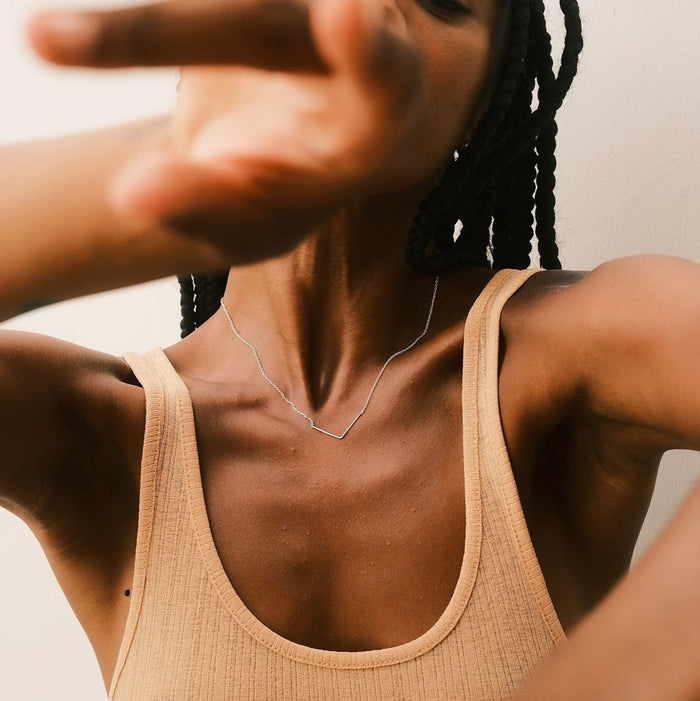 Claudia Silva Conceição porte le collier Unity Triangle en argent, designer par Aurore Havenne