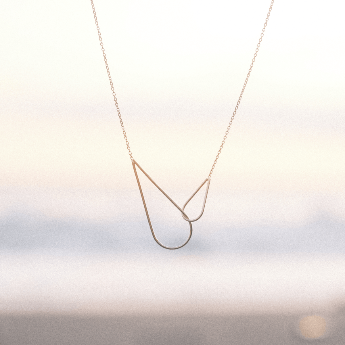 Le collier Raindrops Aurore Havenne, sur un fond de coucher de soleil à Bali