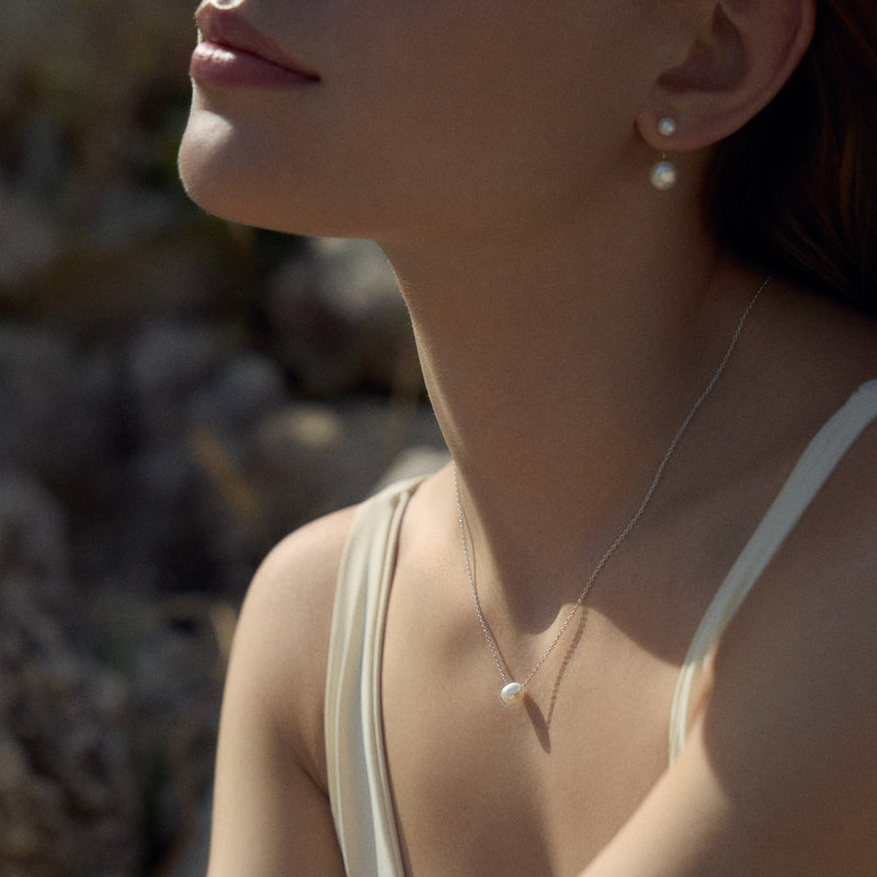 Pair of pearl earrings front and back of the ear