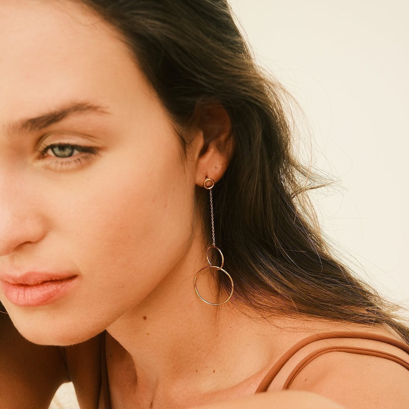 Valerie Rudenko porte les boucles d'oreilles Trinity en argent plaqué or par Aurore Havenne