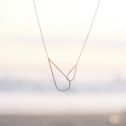 Le collier Raindrops Aurore Havenne, sur un fond de coucher de soleil à Bali